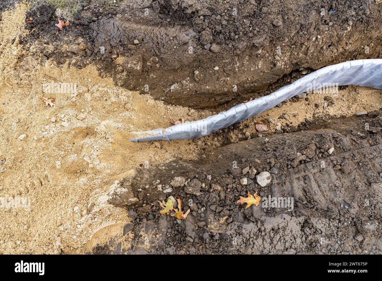 Foto di costruzione del profilo di drenaggio verticale del bordo del campo di atletica per tappeti erbosi naturali, pannello di drenaggio tra l'argilla del campo da baseball da softball e il prato naturale. Foto Stock