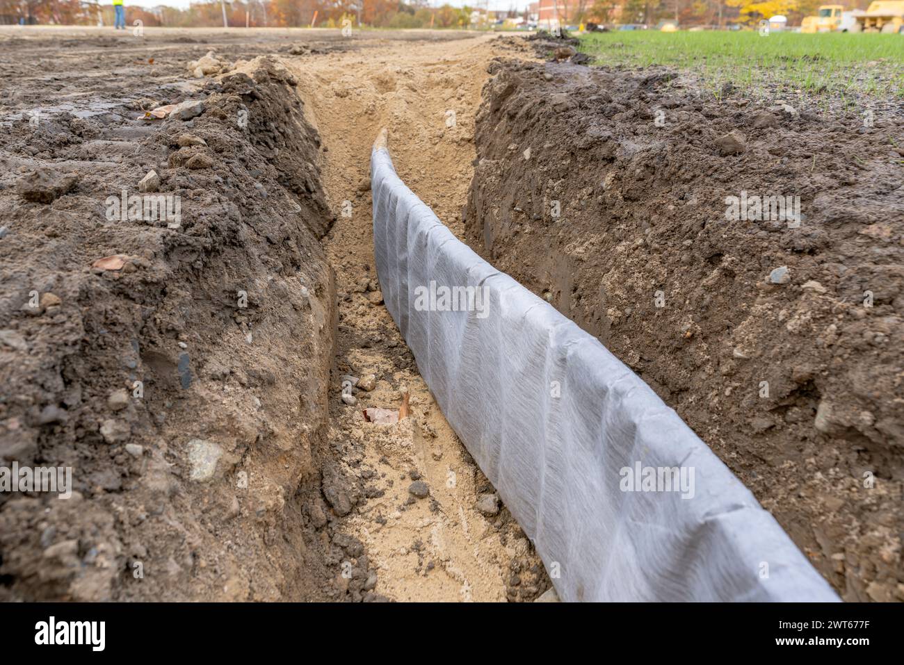 Foto di costruzione del profilo di drenaggio verticale del bordo del campo di atletica per tappeti erbosi naturali, pannello di drenaggio tra l'argilla del campo da baseball da softball e il prato naturale. Foto Stock