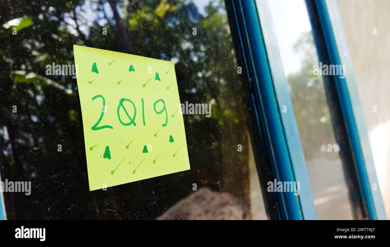 2019 foto di testo con carta verde su sfondo vetro della finestra della casa Foto Stock