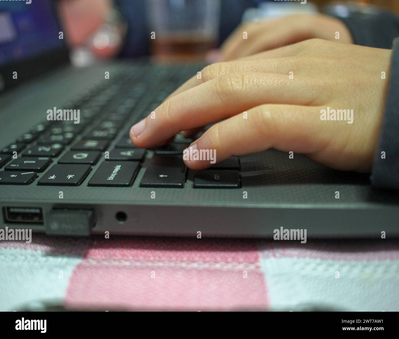 adolescente con un notebook nel tavolo della cucina dopo pranzo Foto Stock