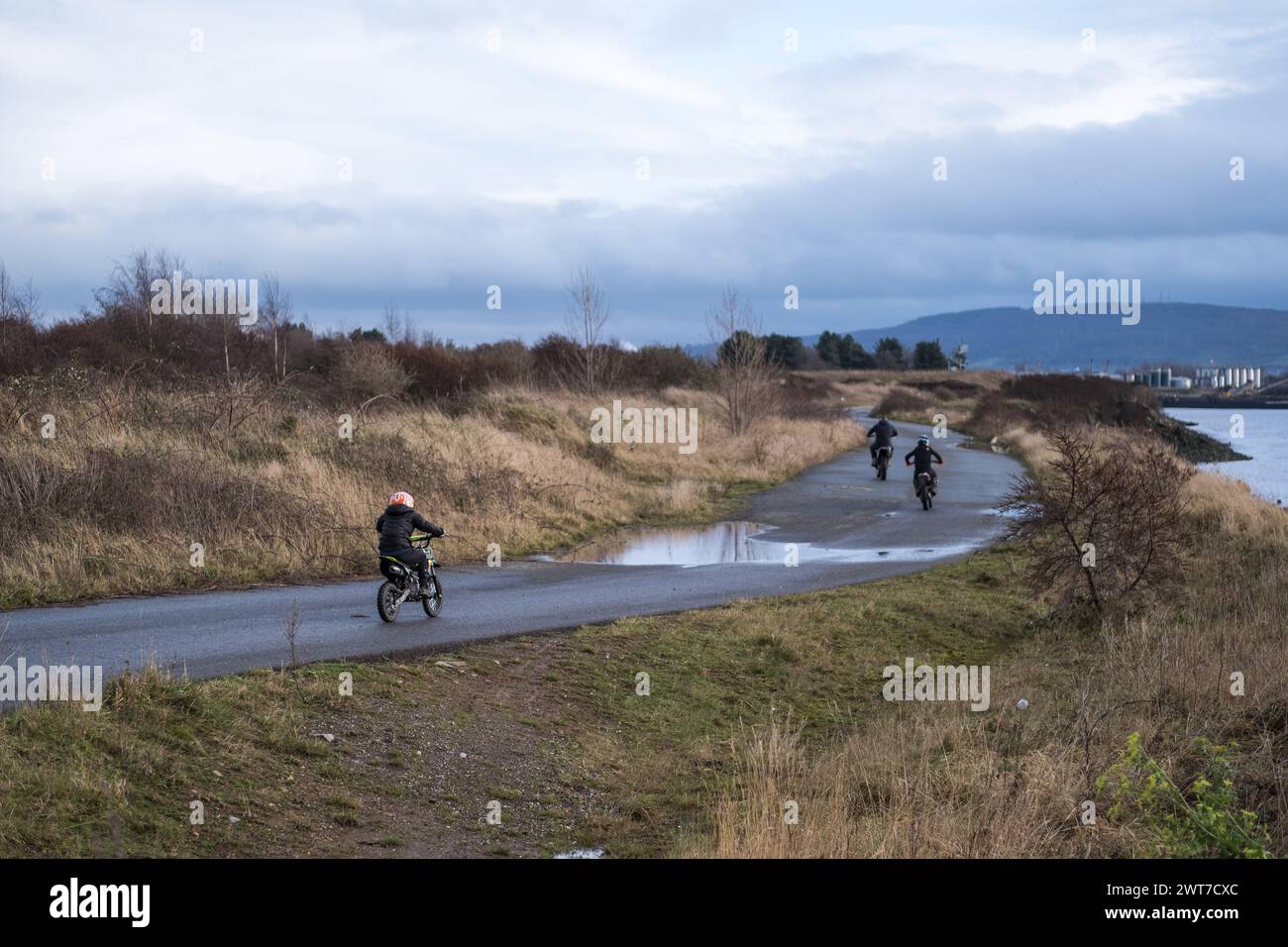 I ragazzi in bici sterrate viaggiano lungo la pista lungo il fiume Tees, a Port Clarence. Teesside, Inghilterra nord-orientale, Regno Unito. Foto Stock