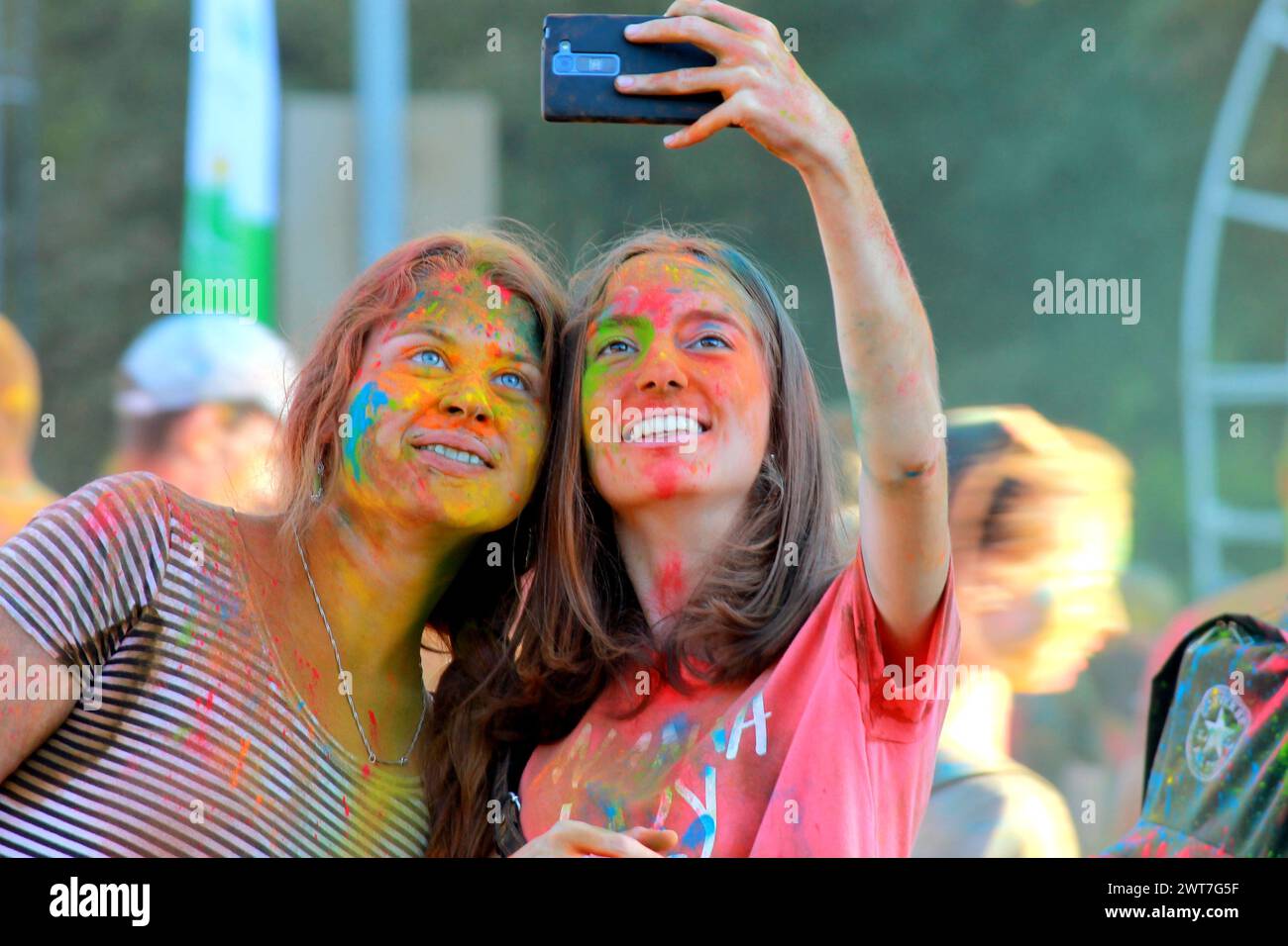 Festa dei colori Holi. I giovani lanciano pitture colorate e si divertono durante il festival Holi. Le ragazze si fanno selfie. Vacanze indiane. Dnipro, Ucraina, 2017-08-2 Foto Stock
