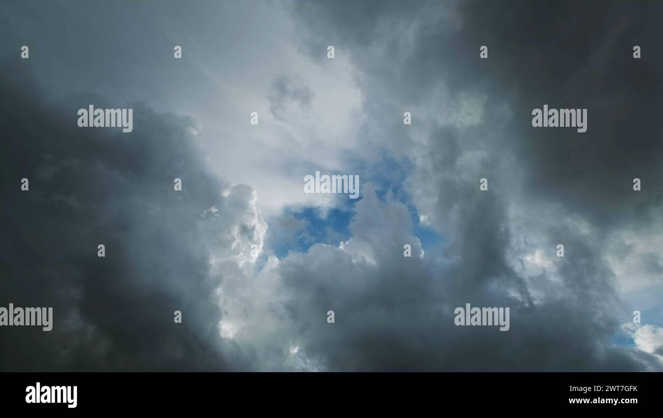 Nuvole di tempesta e buca con il cielo blu Foto Stock