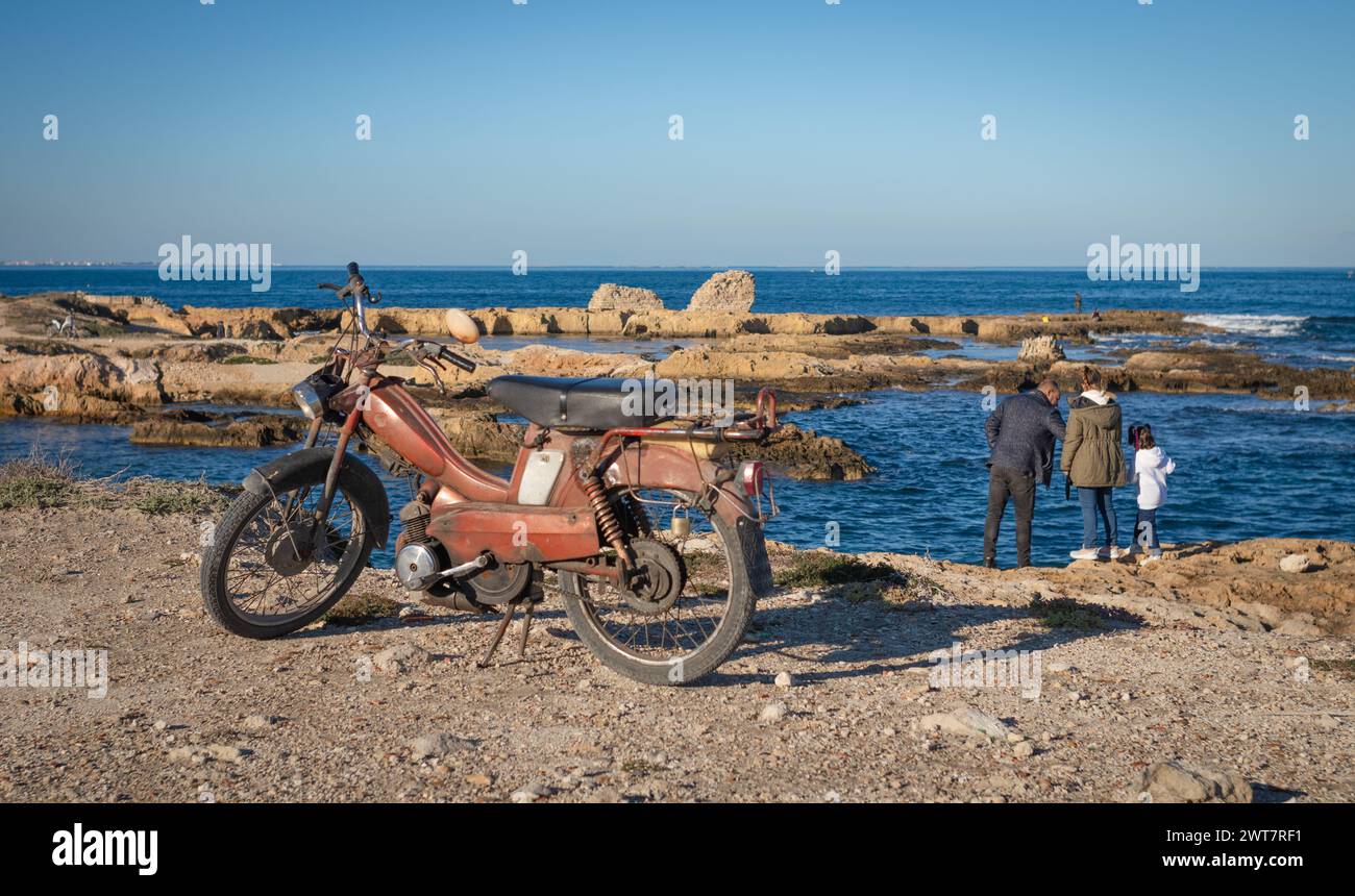 Un vecchio scooter parcheggiato vicino al mare a Borg Errass a Capo Africa, Mahdia, Tunisia Foto Stock