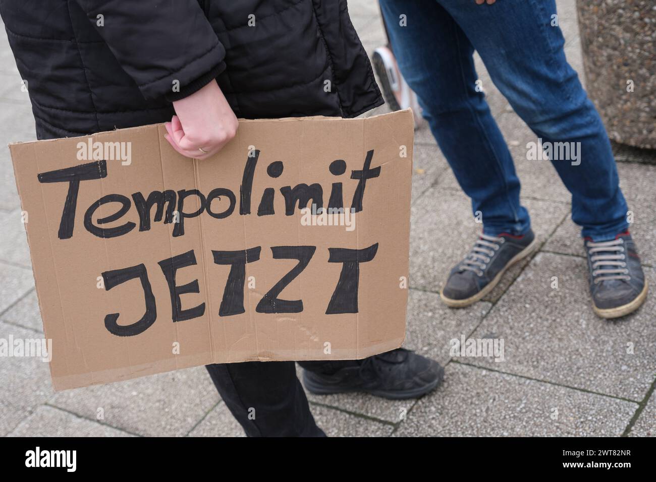 16.03.24: Eine Frau sitzt am Kšlner Ebertplatz auf der Strasse mit einer Grafik der Temperaturentwicklung der letzten Jahre um den Hals. Heute startet Foto Stock