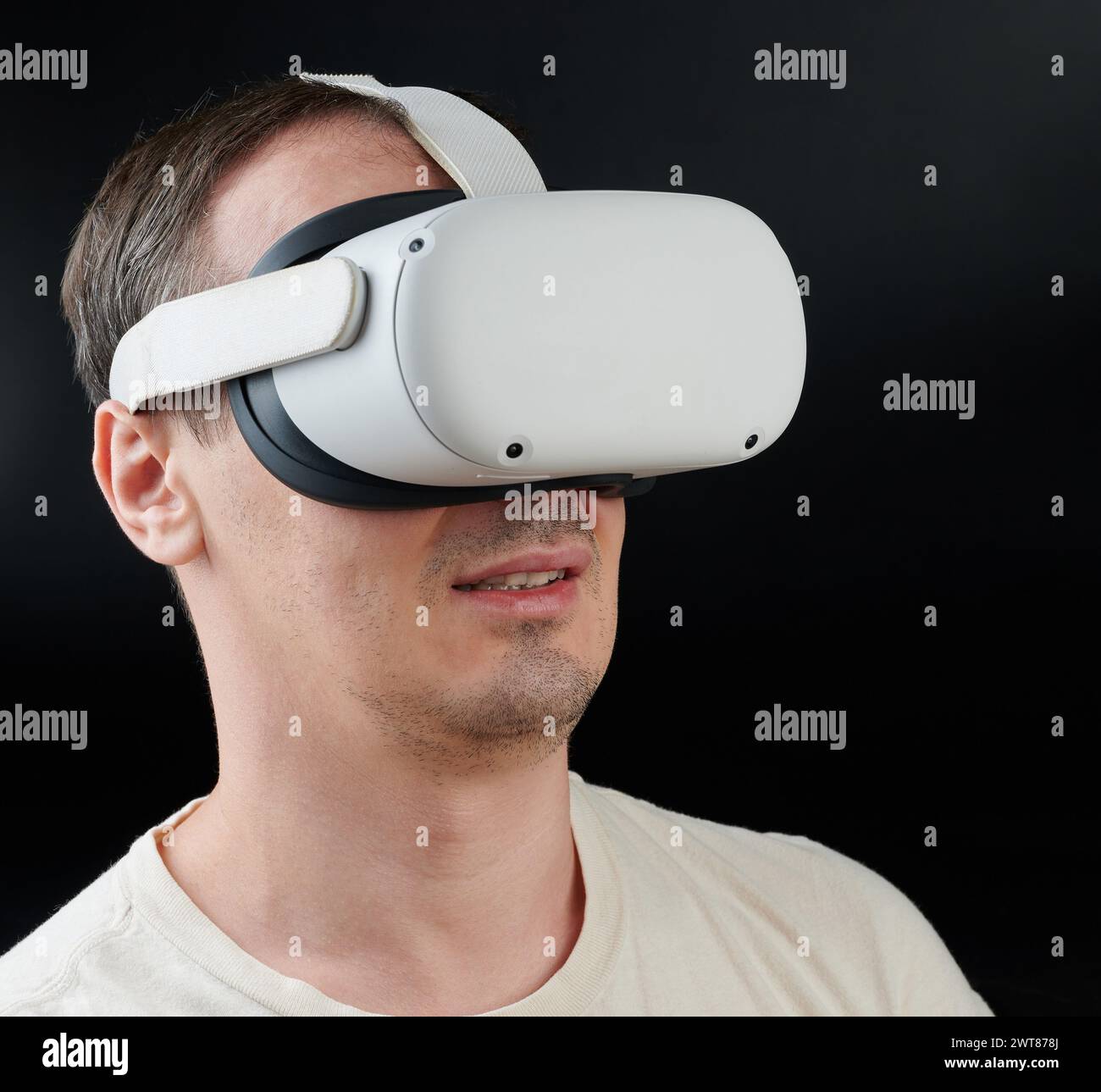 Uomo che guarda film con visore VR con vista laterale verticale isolata su sfondo nero Foto Stock