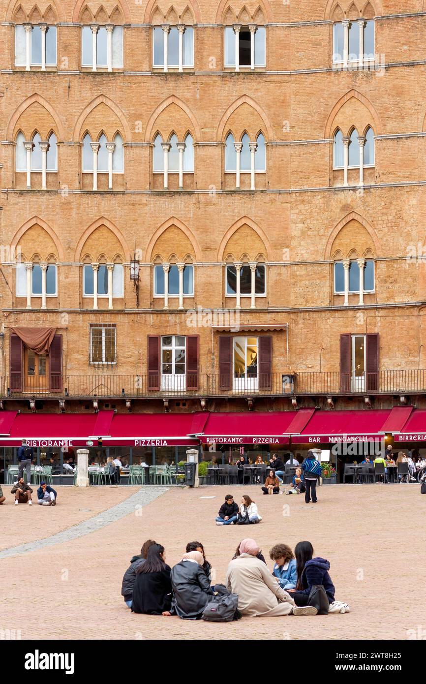 La gente si reca a Piazza del campo, la magnifica piazza principale della città medievale di Siena, in Toscana, Italia, Europa. Foto Stock