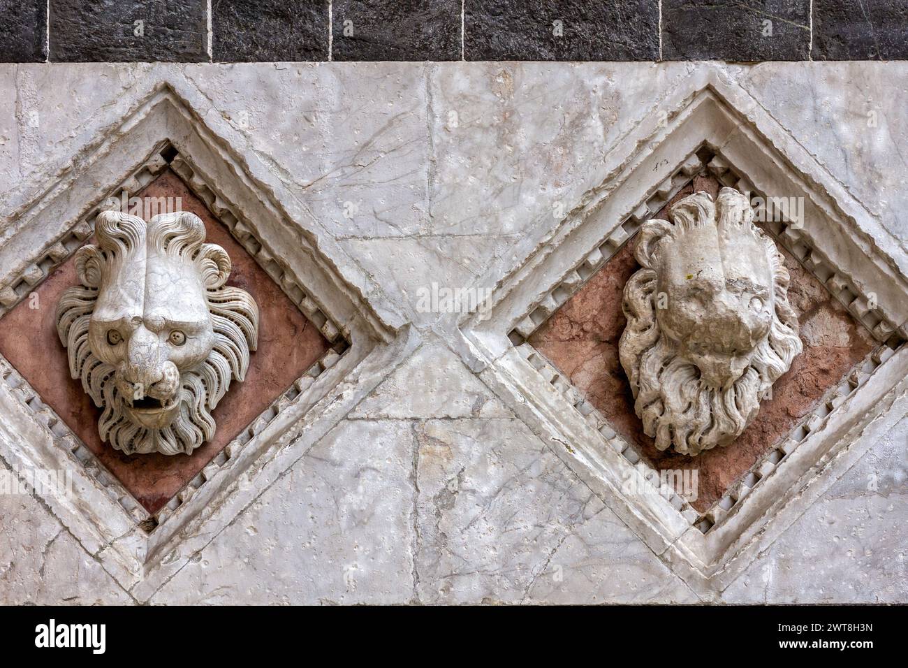 Testa dei leoni scolpita sulla facciata del Battistero di San Giovanni (Battistero di San Giovanni) a Siena, Toscana, Italia, Europa. Foto Stock