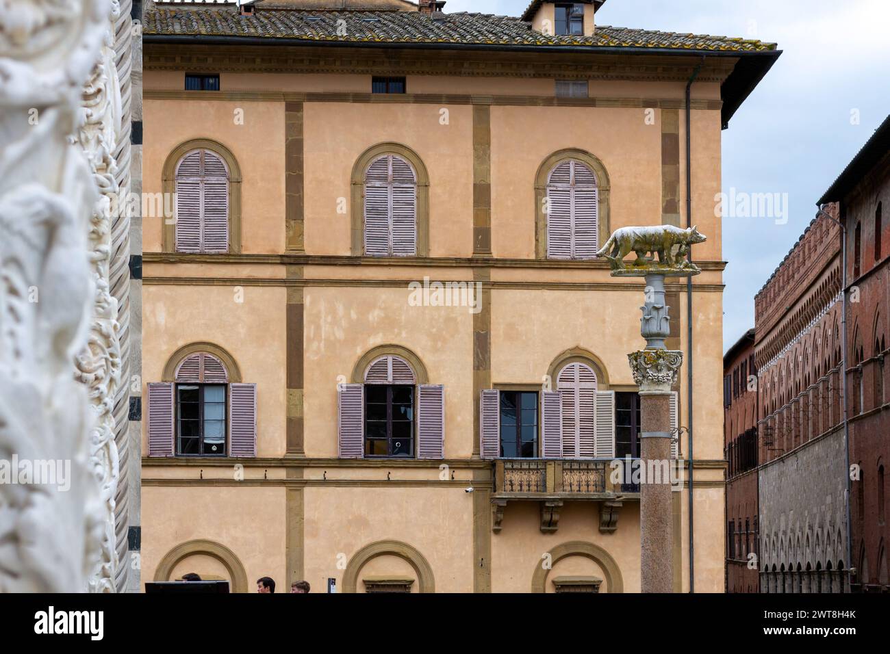Dettaglio architettonico esterno al Duomo di Siena, con vista parziale dell'edificio della Prefettura di Siena e del Duomo di Siena. Foto Stock