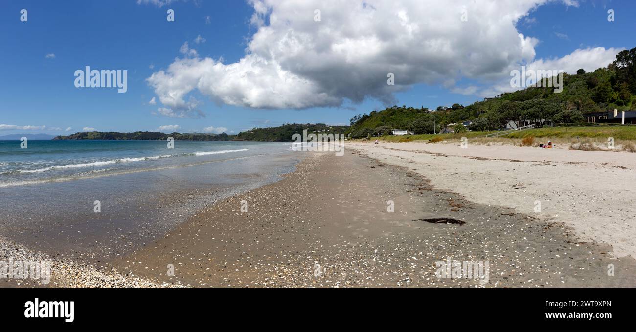 Panorama della spiaggia di Onetangi con conchiglie, turisti e case in collina sull'Isola di Waiheke, Aotearoa / nuova Zelanda Foto Stock