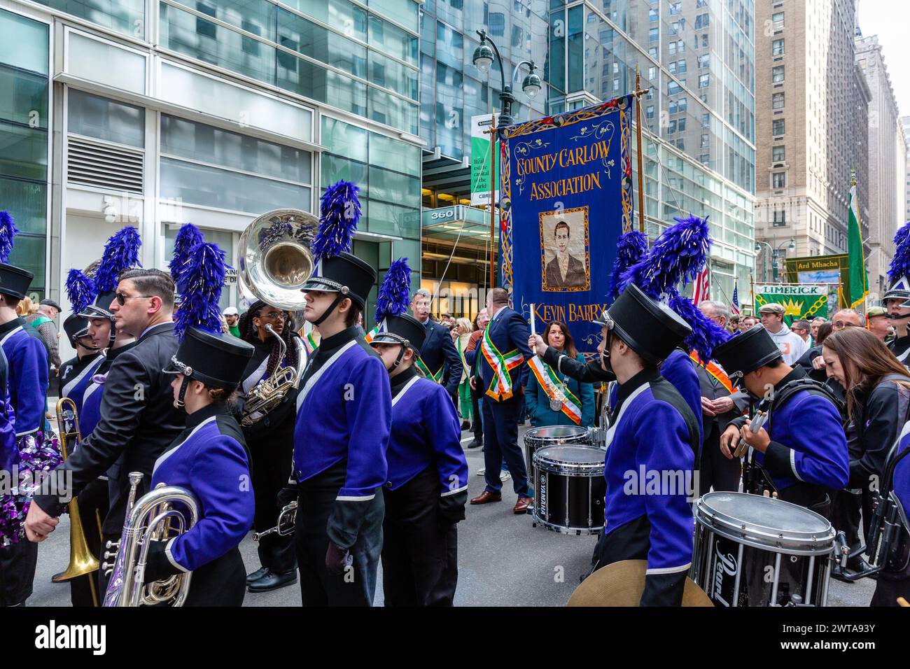 New York, New York, Stati Uniti. 16 marzo 2024. Contingenti irlandesi-americani hanno preso il via dalla St. Di New York Patrick's Day Parade con le melodie di numerose bande di pipe e applaudito da schiere di spettatori, molti addobbati di verde. La County Carlow Association e la Duncan U. Fletcher High School Band, entrambe in colori simili, aspettano di iniziare. Crediti: Ed Lefkowicz/Alamy Live News Foto Stock