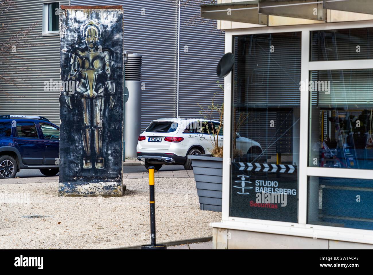 Una sezione del muro di Berlino con l'uomo delle macchine Maria del monumentale film muto Metropolis del 1927. Ingresso e vialetto di accesso al sito di produzione dello Studio Babelsberg, August-Bebel-Straße, Potsdam, Brandeburgo, Brandeburgo, Germania Foto Stock