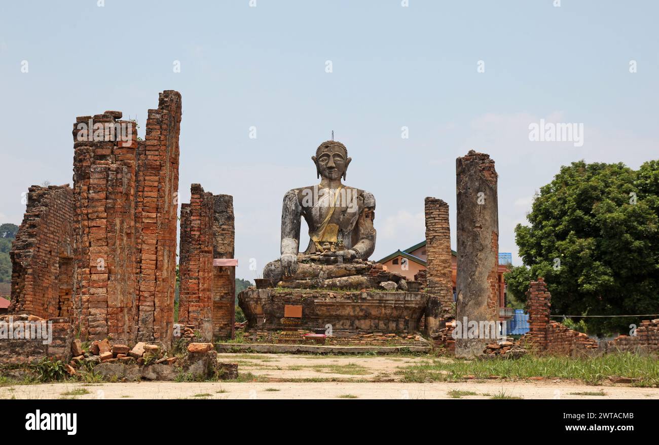 Le rovine di Wat Phia Wat vicino a Phonsavan in Laos. L'area è stata oggetto di bombardamenti durante la guerra del Vietnam e questa statua di buddha e alcune pareti sono tutte Foto Stock