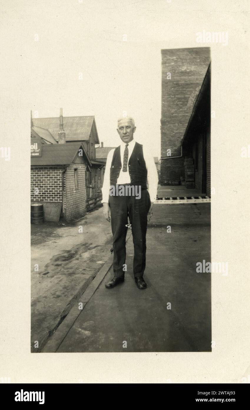 Un uomo in un vicolo fuori dal petrolio che cambia affari negli anni '1920, '1930 Foto Stock