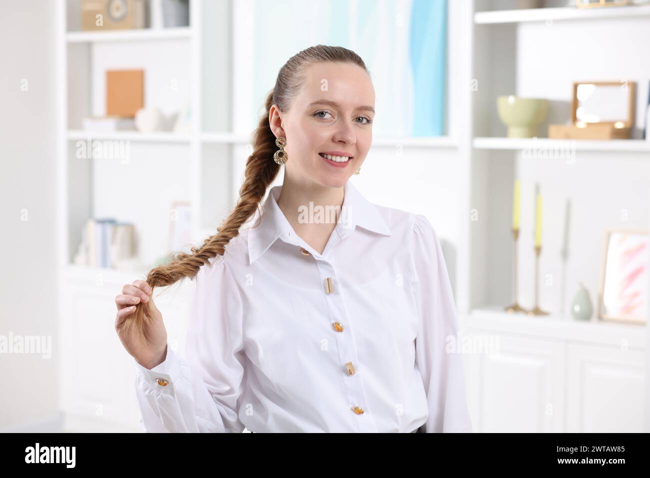 Donna con lunghi capelli intrecciati a casa Foto Stock