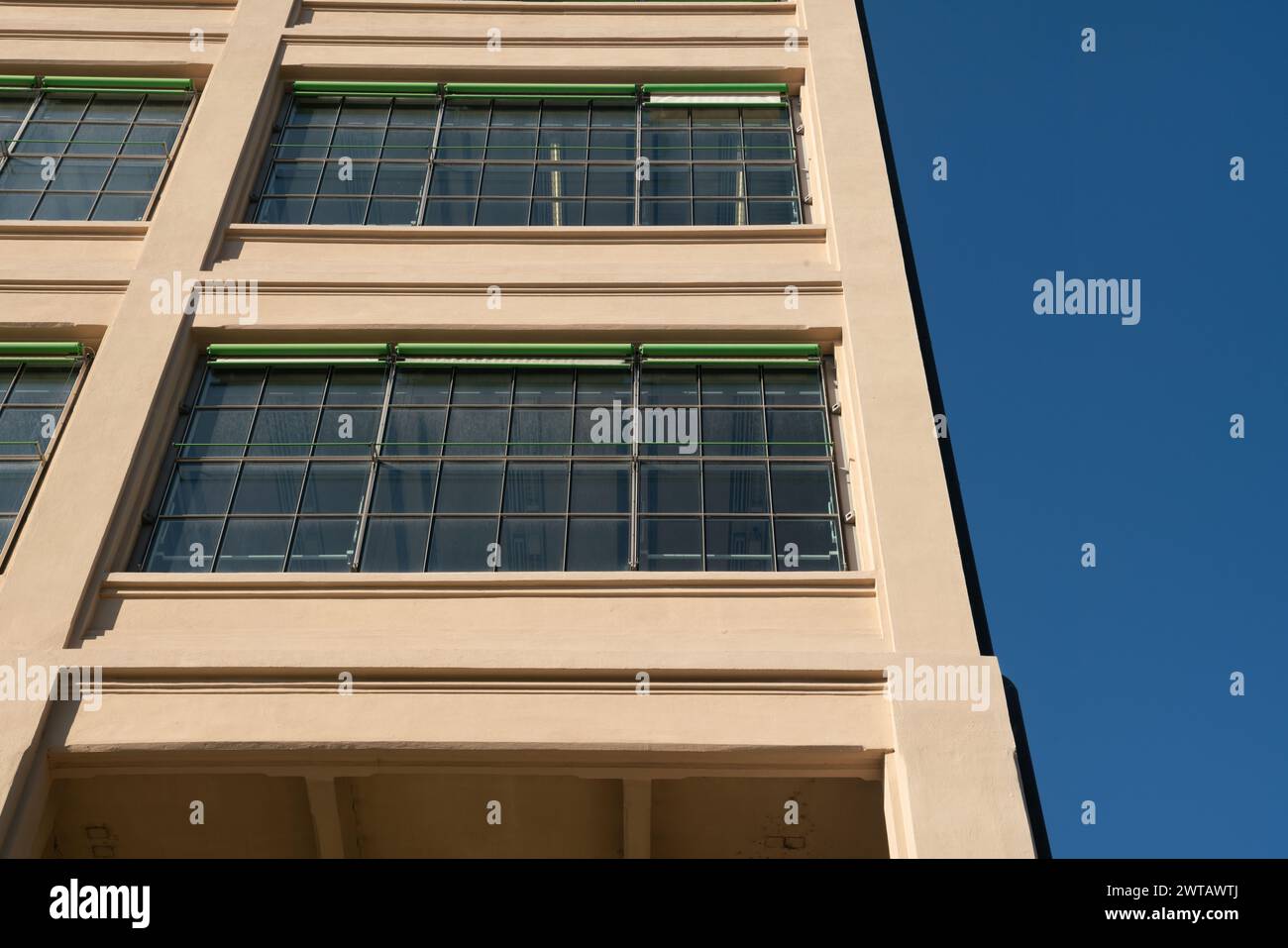edificio post-industriale riqualificato con spazi multifunzionali, struttura in cemento armato e finestre e tende esterne a doppi vetri. Torino, Foto Stock