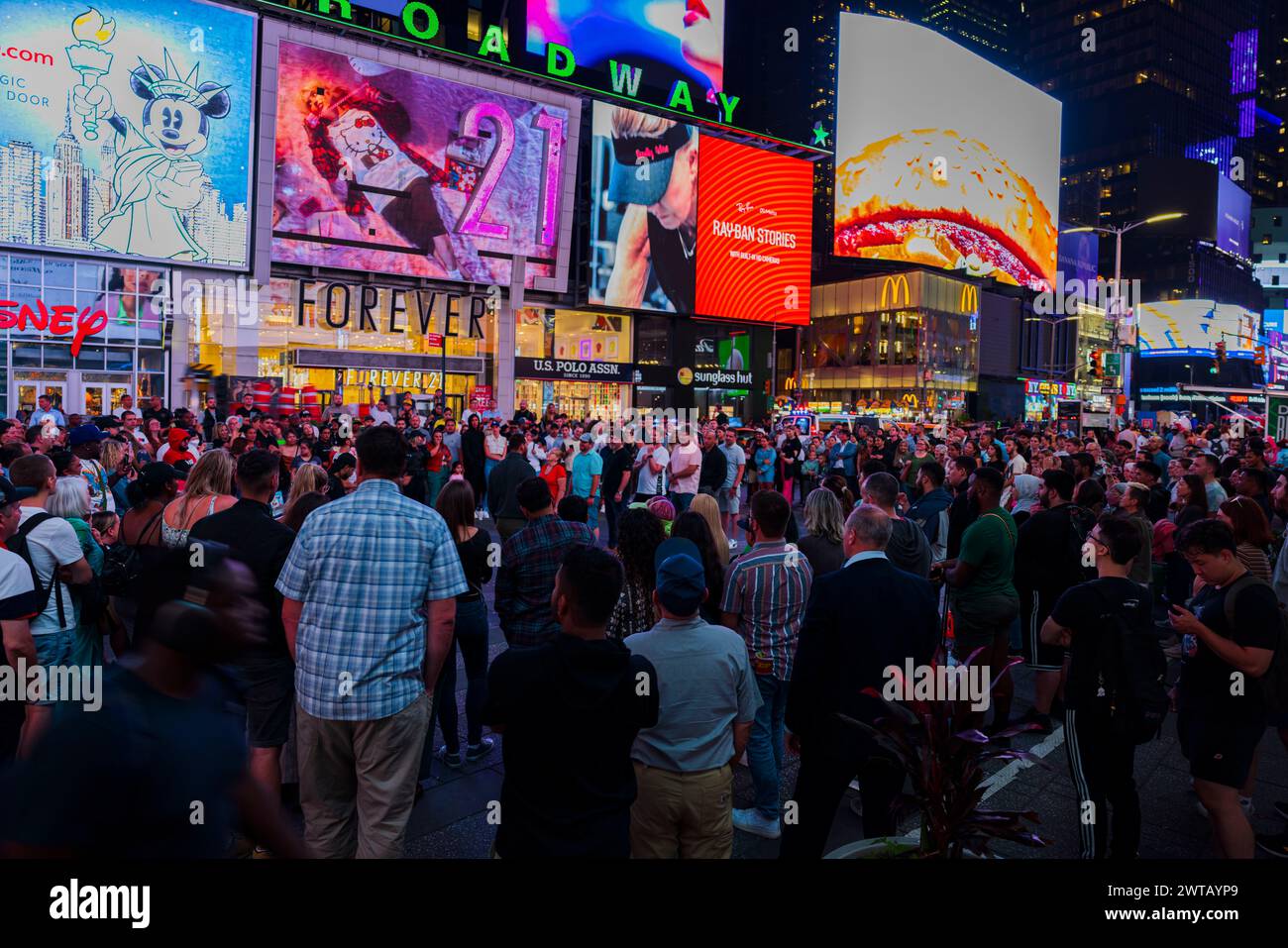 Di notte, Times Square si riempie di attività mentre la folla passeggia lungo Broadway, immergendosi nella vivace atmosfera di New York City. STATI UNITI. Foto Stock