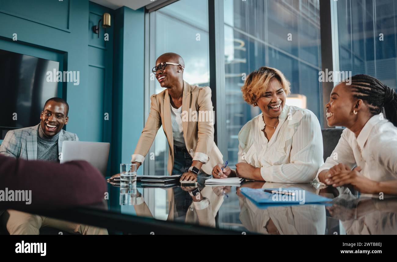 Incontro di lavoro di successo in un ufficio aziendale con un gruppo felice di uomini e donne professionisti. Lavorano insieme, mostrando lavoro di squadra e leader Foto Stock