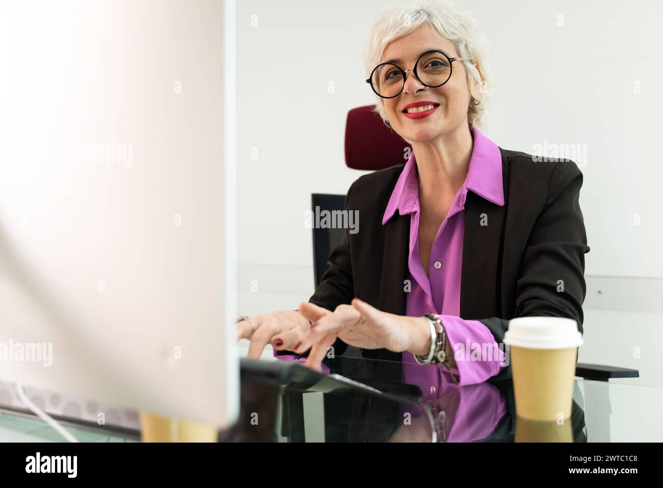 Donna professionista esperta che interagisce con i colleghi in un ufficio aziendale - leadership e competenza. Foto Stock