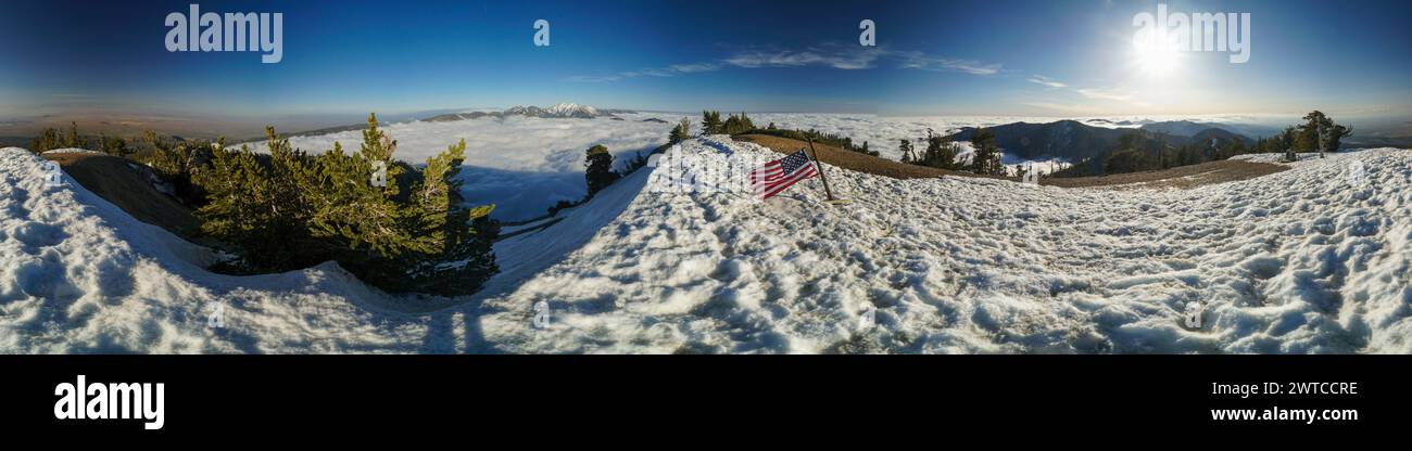 Una vista panoramica di una montagna innevata con una bandiera americana rossa e bianca sul terreno Foto Stock