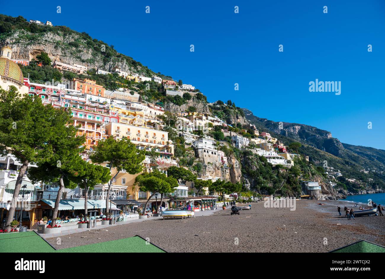 Positano, Italia - 19 dicembre 2022: Immagine vibrante della pittoresca cittadina costiera di Positano con edifici colorati che salgono sulla collina sotto un blu chiaro Foto Stock