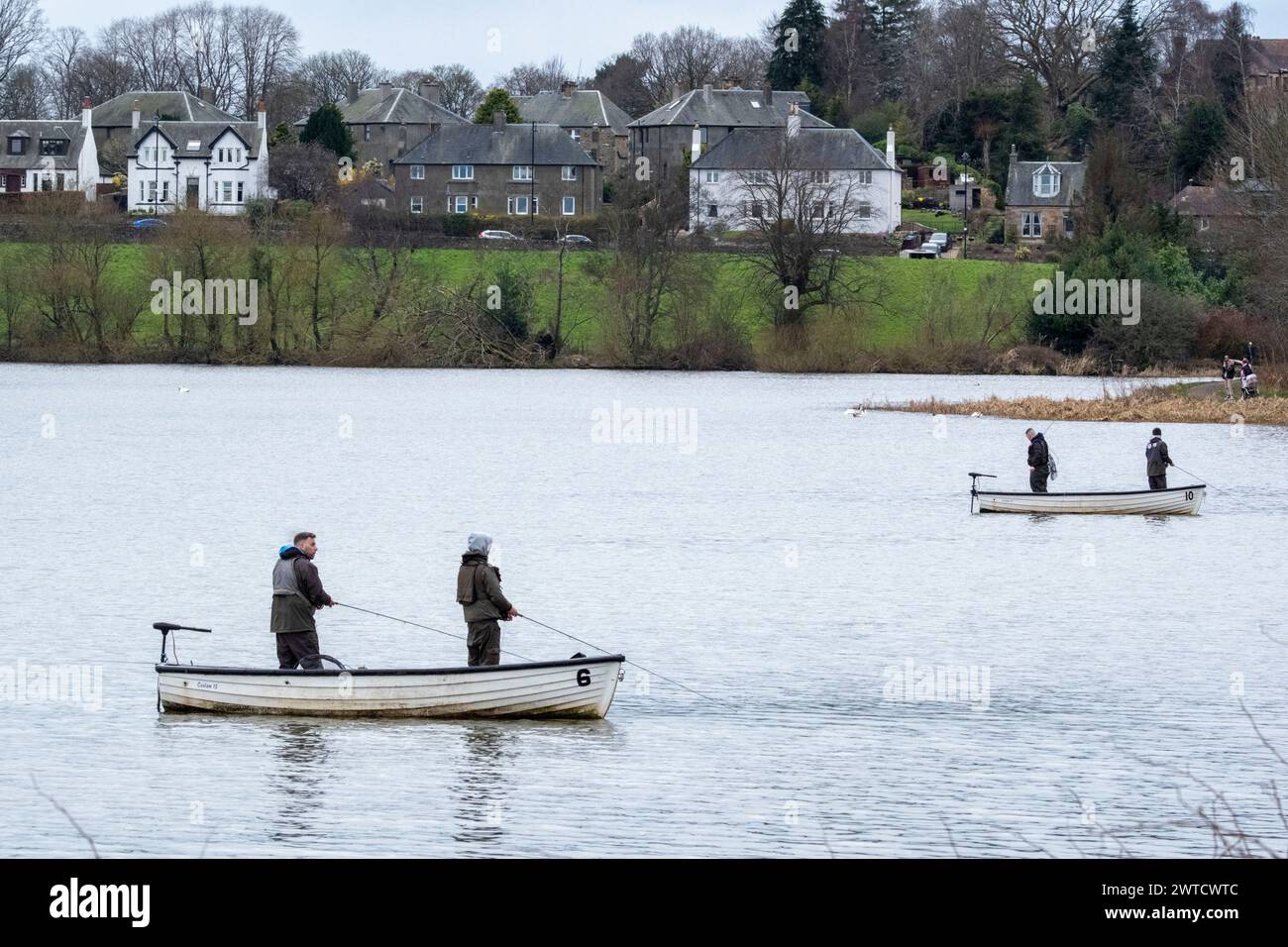 Gente che pesca da barche a Linlithgow Loch, Scozia, Regno Unito Foto Stock