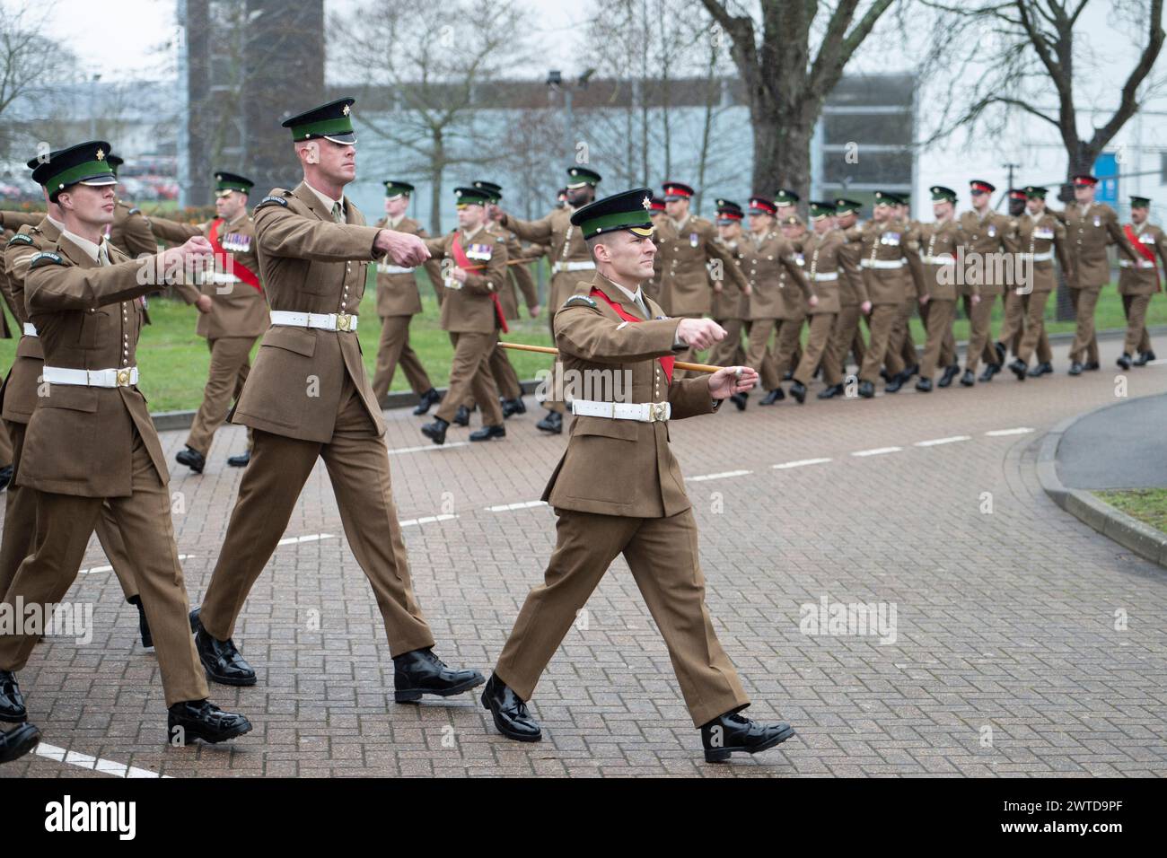 Mons Barracks, Aldershot, Hampshire, Regno Unito. 17 marzo 2024. L'Irish Guards Regiment si riunisce in una speciale St. Patrick's Day Parade e festeggiamenti ad Aldershot. La sfilata è un punto culminante dell'anno per questo reggimento a doppio ruolo, che apprezza le sue radici culturali irlandesi. La parata è composta dal 1st Battalion Irish Guards, numero 9 Company Irish Guards, numero 12 Company Irish Guards, la Band of the Irish Guards, riserve dal numero 15 (Loos) Company Irish Guards (The London Guards), veterani e cadetti della Irish Guards, e l'inimitabile Irish Guards Pipes e Regimental Irish Wolfhound Mascot, Foto Stock