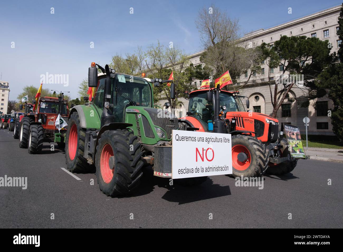 Diversi trattori durante una protesta da parte di agricoltori e allevatori per chiedere miglioramenti nel settore rurale nel centro di Madrid, il 17 marzo 2024. Foto Stock