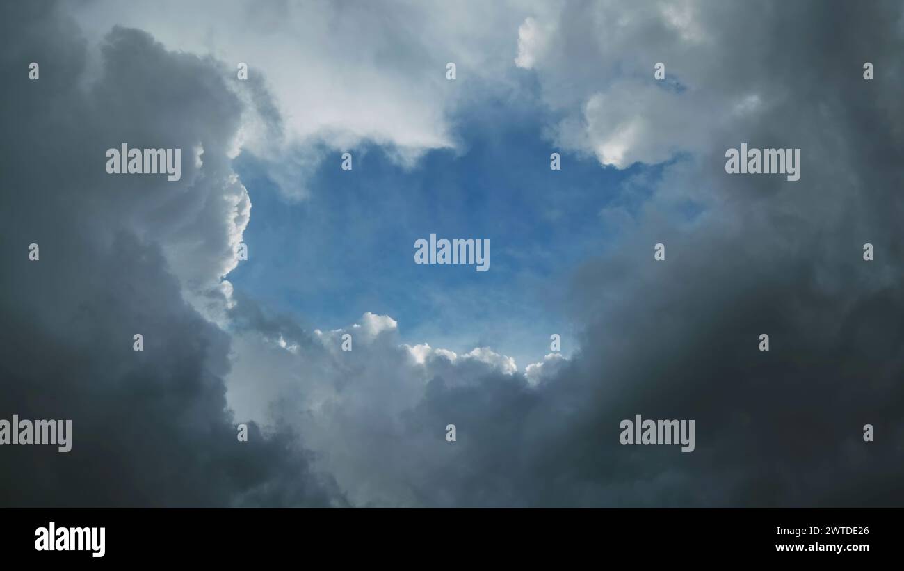 Nuvole di tempesta e buca con il cielo blu Foto Stock
