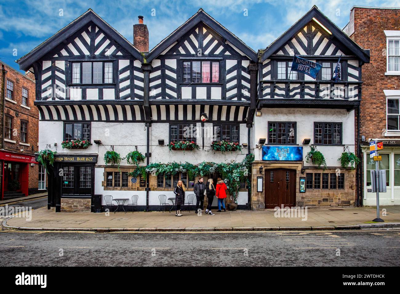Persone fuori dal Kings Head and Haunted Hotel in Lower Bridge Street, Chester Cheshire, un vecchio albergo di carrozze in legno bianco e nero Foto Stock