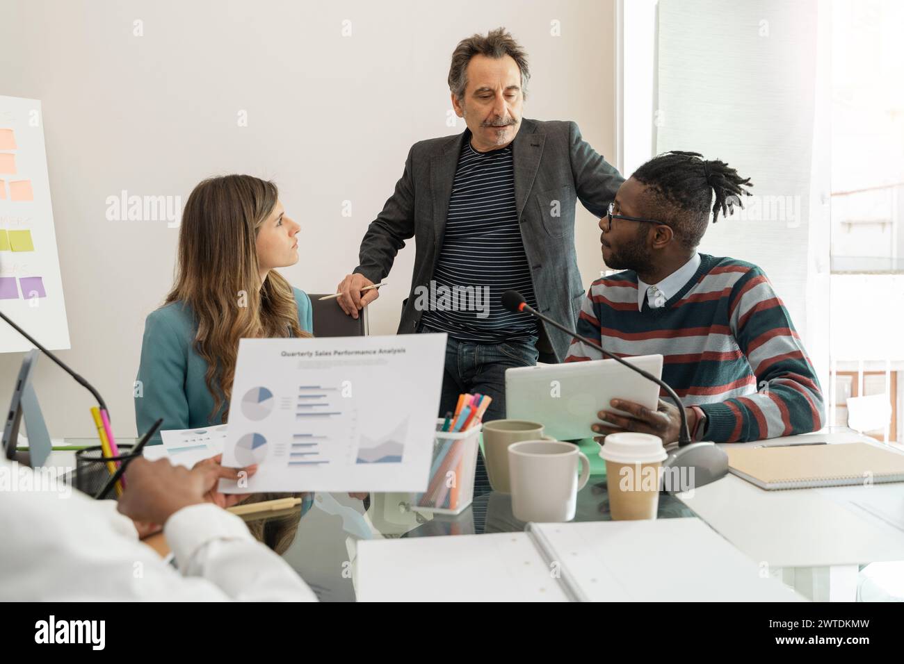 Team multiculturale impegnato nella discussione sull'analisi aziendale - una collaborazione vivace in un ufficio moderno - che illustra il lavoro di squadra e la pianificazione strategica Foto Stock