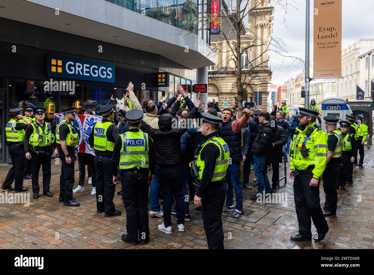 Leeds, Regno Unito. 17 MARZO 2024. I tifosi del Millwall nel centro di Leeds marciano verso Elland Road per la partita di calcio nel campionato contro il Leeds United. Guidati da pesanti controlli, i tifosi entrarono in campo senza incidenti importanti, i canti sgradevoli sono stati fatti dal gruppo durante tutto il tempo. Credito Milo Chandler/Alamy Live News Foto Stock