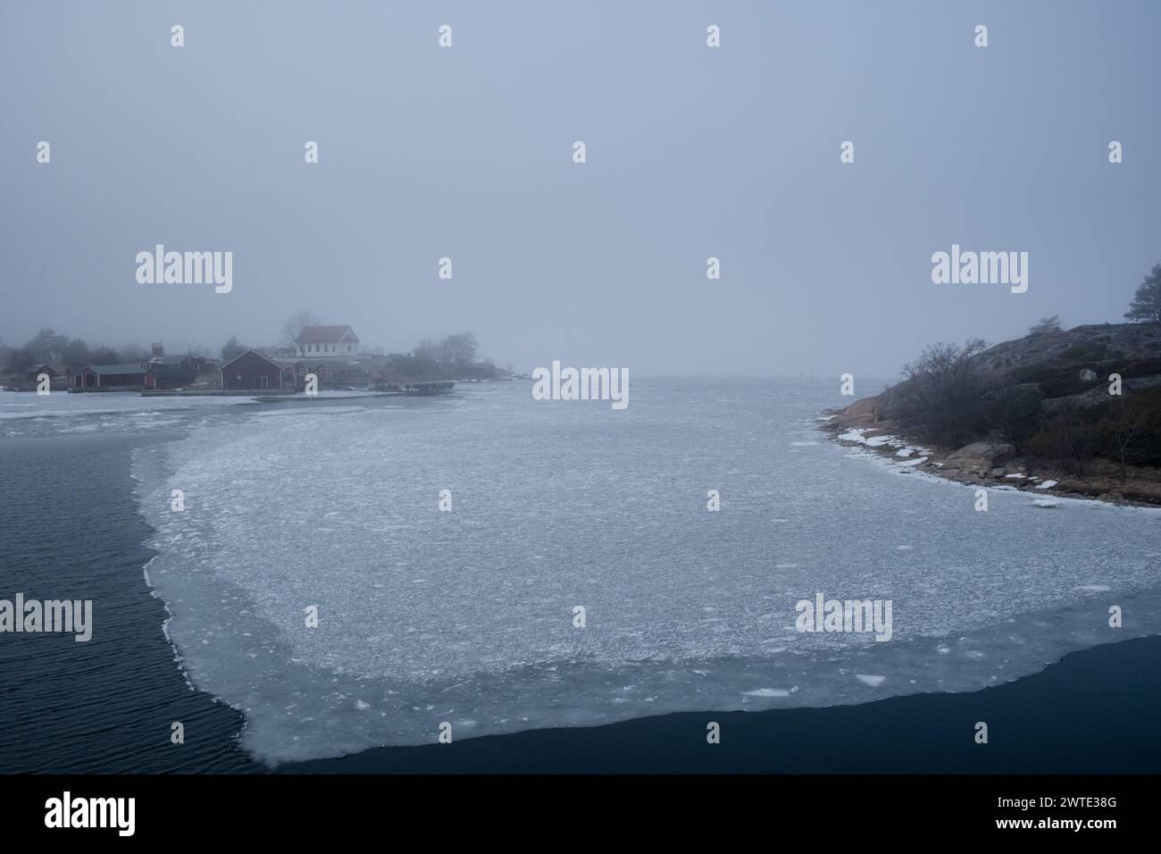 ASPÖ, TRAGHETTO MS UTÖ, ARCIPELAGO DI TURKU: Il traghetto locale gratuito MS Utö atterra sull'isola di Aspö nel bellissimo arcipelago di Turku in una fredda giornata invernale ghiacciata nella nebbia gelida. INFO: L'arcipelago di Turku, situato nel Mar Baltico al largo della costa sud-occidentale della Finlandia, comprende migliaia di isole e isolotti. I suoi paesaggi pittoreschi, punteggiati da pittoreschi villaggi e monumenti storici, attraggono visitatori alla ricerca di tranquillità, avventure all'aperto e fascino marittimo. Foto Stock