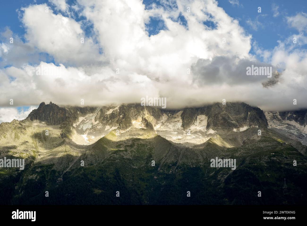 Paesaggio montano con una vista incredibile sulla valle fino alle montagne innevate coperte di nuvole basse Foto Stock