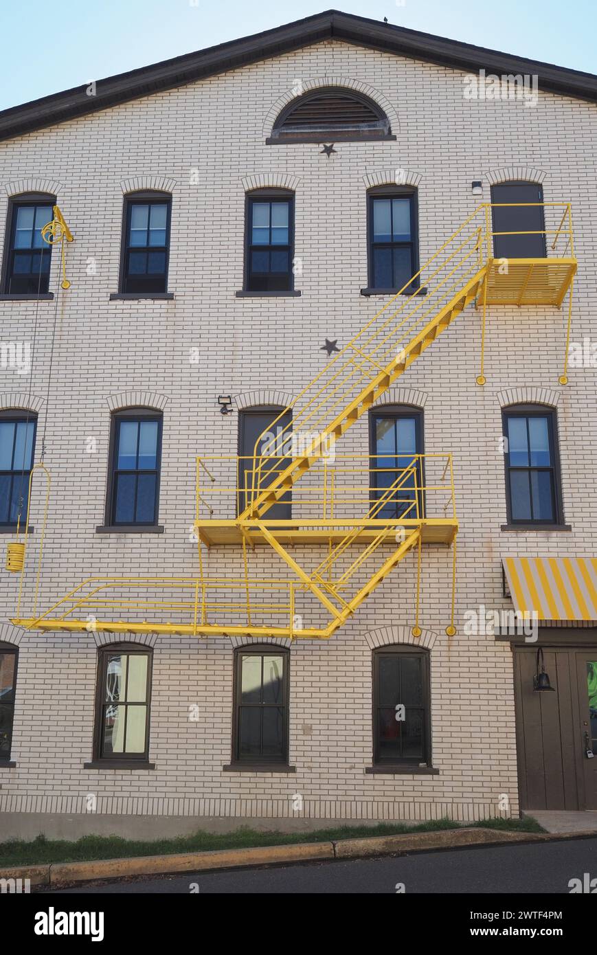La scala antincendio è di colore giallo brillante invece del solito nero. Foto Stock La scala antincendio è di colore giallo brillante invece del solito nero. Foto Stock