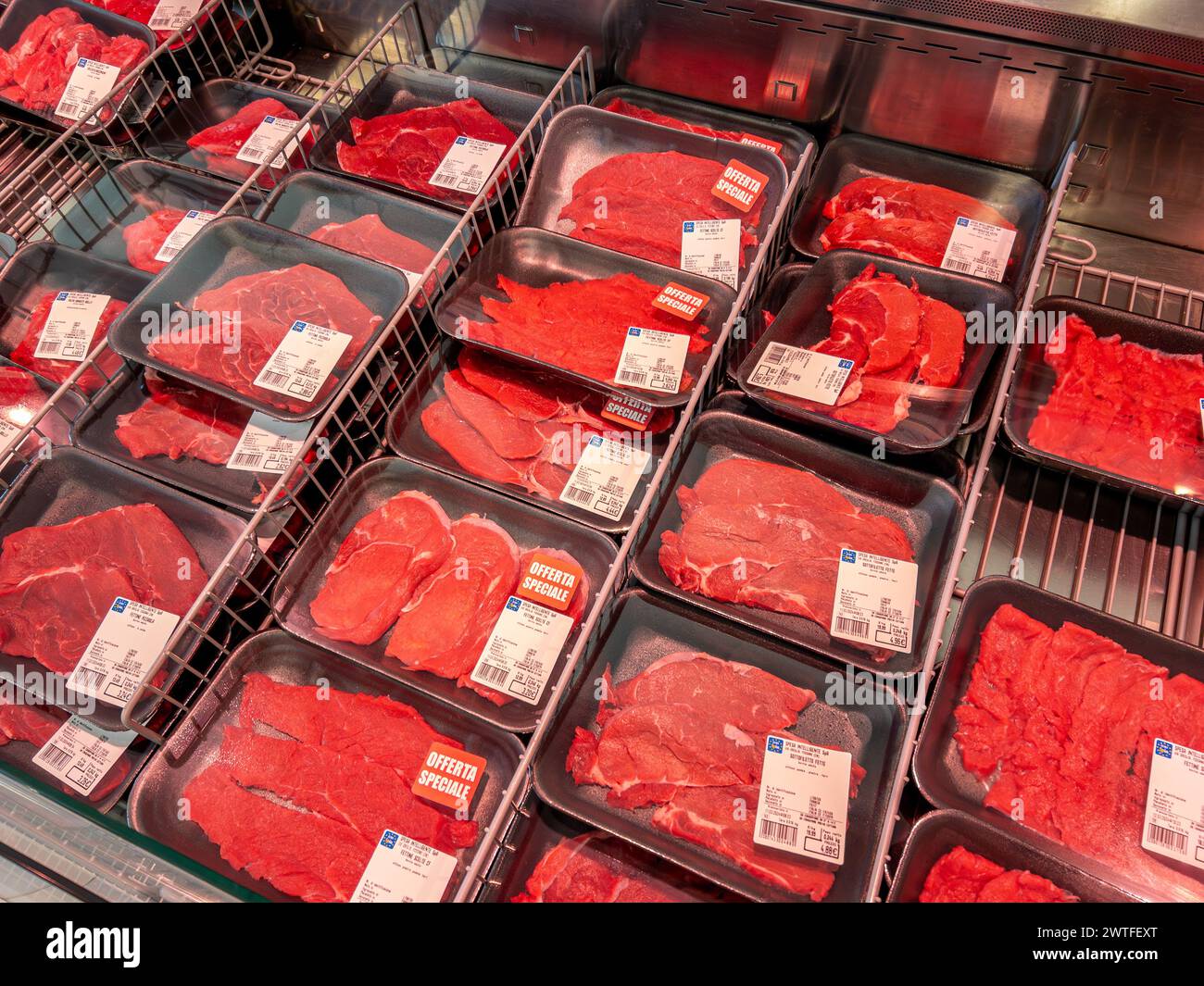 Italia - 12 marzo 2024: Bistecche di manzo in vassoi di plastica esposte in bancone refrigerato in vendita presso il discount italiano EuroSpin Foto Stock