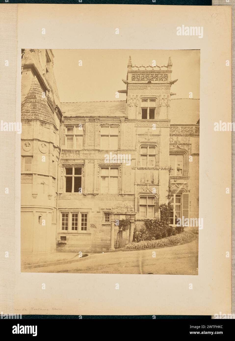 Château de Fontaine-Henri. William J. Stillman, fotografo (americano, 1828 - 1901) circa 1861 Vista di un angolo interno del Château de Fontaine-Henry. L'edificio presenta medaglioni scolpiti con figure diverse, per lo più di profilo, intorno ad una torre poligonale che si trova su un angolo dell'edificio. Rifinisci intorno alle finestre e tra il piano terra, il primo e il secondo piano, presenta intagli dettagliati e schermi intagliati che fiancheggiano le parti del tetto presentano motivi intricati. (Recto, monta) in alto a destra, scritto a mano a matita: "17"; in basso a sinistra, scritto a mano a matita: "[parzialmente coperto b Foto Stock