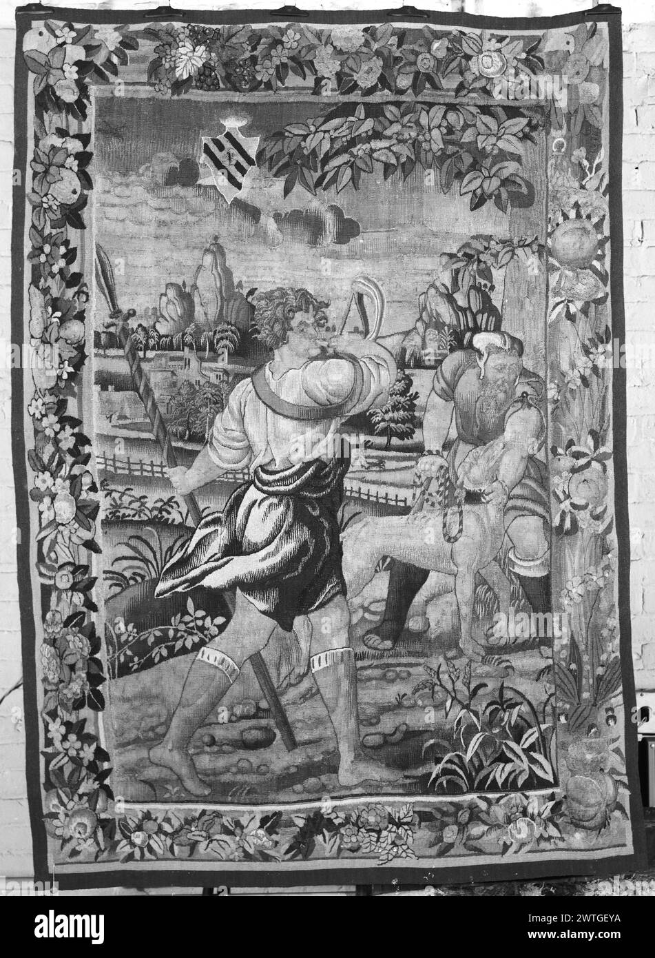 Scena di caccia. Sconosciuto c. 1535-1550 arazzi dimensioni: H 6'5,5' x W 4'5' arazzo materiali/tecniche: Sconosciuto Cultura: Flemish Weaving Center: Sconosciuto storia di proprietà: French & Co. Acquistato da Rewell McCallum 6/8/1951. Nel paesaggio, il cacciatore soffia il corno di caccia mentre un altro cacciatore blocca il cane da caccia; stemma visto nel cielo (BRD) ghirlande di fiori e frutta intervallate da fronde e grappoli di uva l'arazzo sembra essere un frammento; bordo con pezzi provenienti da più di 1 arazzo. French & Co. Foglio di magazzino in archivio, 50855-x Foto Stock