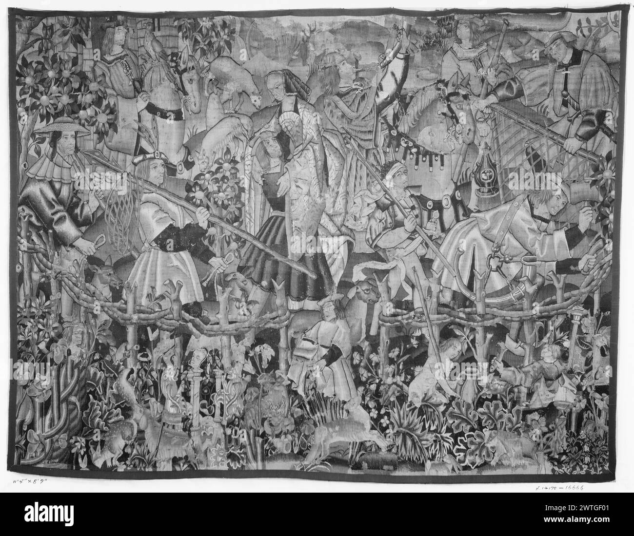 Festa di caccia. Sconosciuto c. 1500-1535 arazzi dimensioni: H 8'6' x W 11'5' arazzo materiali/tecniche: Sconosciuta Cultura: Paesi Bassi meridionali tessitura Centro: Sconosciuta Proprietà storia: French & Co.. All'interno del parco giochi, personaggi in varie attività, tra cui cacciatori di cavalli che tengono il falco; 2 uomini che camminano con cani da caccia e reti; coppie che abbracciano; uomo che fa pali di recinzione; vari animali raccolti all'esterno del parco di caccia, tra cui conigli, rainoni e leoni le 2 fotografie indicano una notevole rilavorazione di questo pannello, specialmente lungo il bordo inferiore. Si può ragionevolmente supporre che il Po Foto Stock