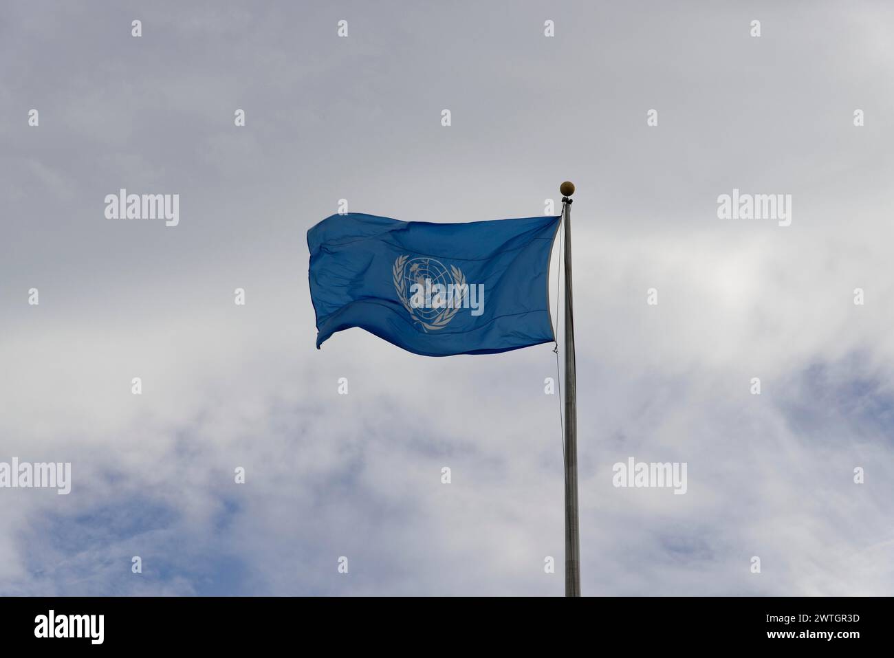 Quartier generale delle Nazioni Unite, East River, Manhattan, bandiera delle Nazioni Unite che sventola nel vento con un cielo nuvoloso sullo sfondo, New York City, New York, USA Foto Stock