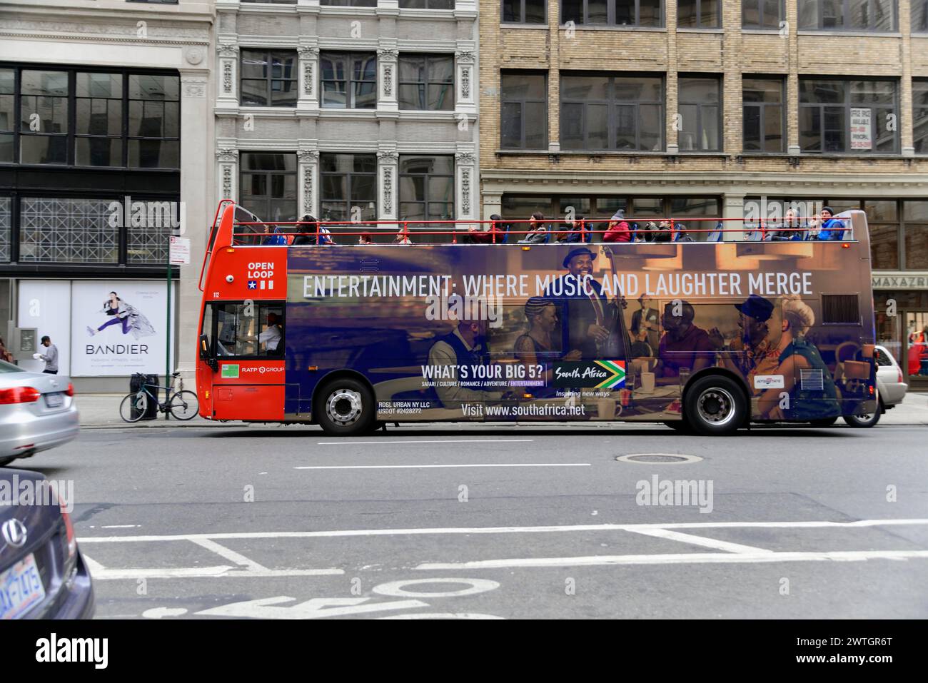 Un autobus turistico rosso che pubblicizza l'intrattenimento attraversa la città, Manhattan, New York, New York, Stati Uniti, nord America Foto Stock