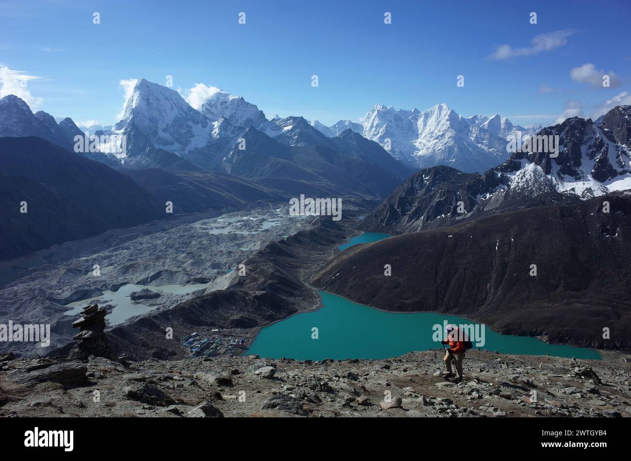 Escursione in Nepal Himalaya, turista maschile che cammina fino a Gokyo Ri con vista sul lago Gokyo, il villaggio di Gokyo, il ghiacciaio Ngozumba e le montagne. Alta quota g Foto Stock