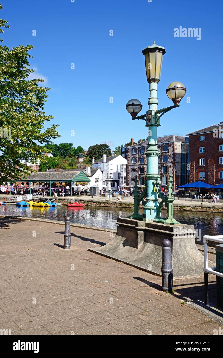 Semaforo vecchio stile lungo la riva del fiume con vista sul fiume exe verso i negozi e i ristoranti lungo East Quay, Exeter, Devon, Regno Unito. Foto Stock