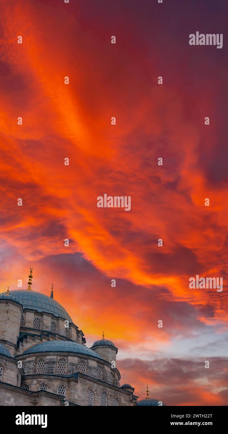 Foto verticale Ramadan o concetto islamico. Nuova Moschea di Eminonu o Yeni Cami con spettacolari nuvole al tramonto. Foto Stock