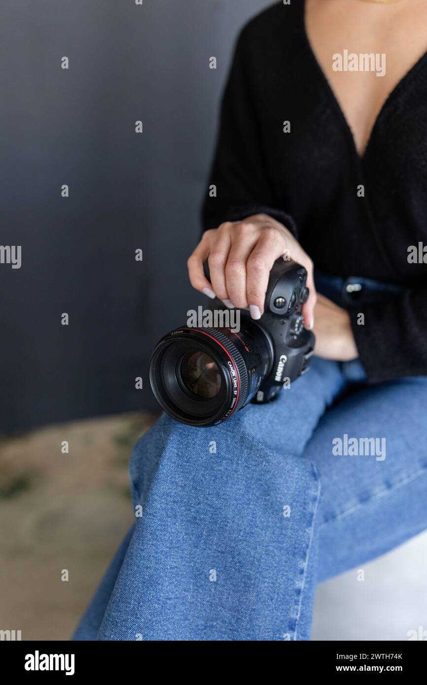 Una ragazza che tiene in mano una fotocamera DSLR Canon, primo piano Foto Stock