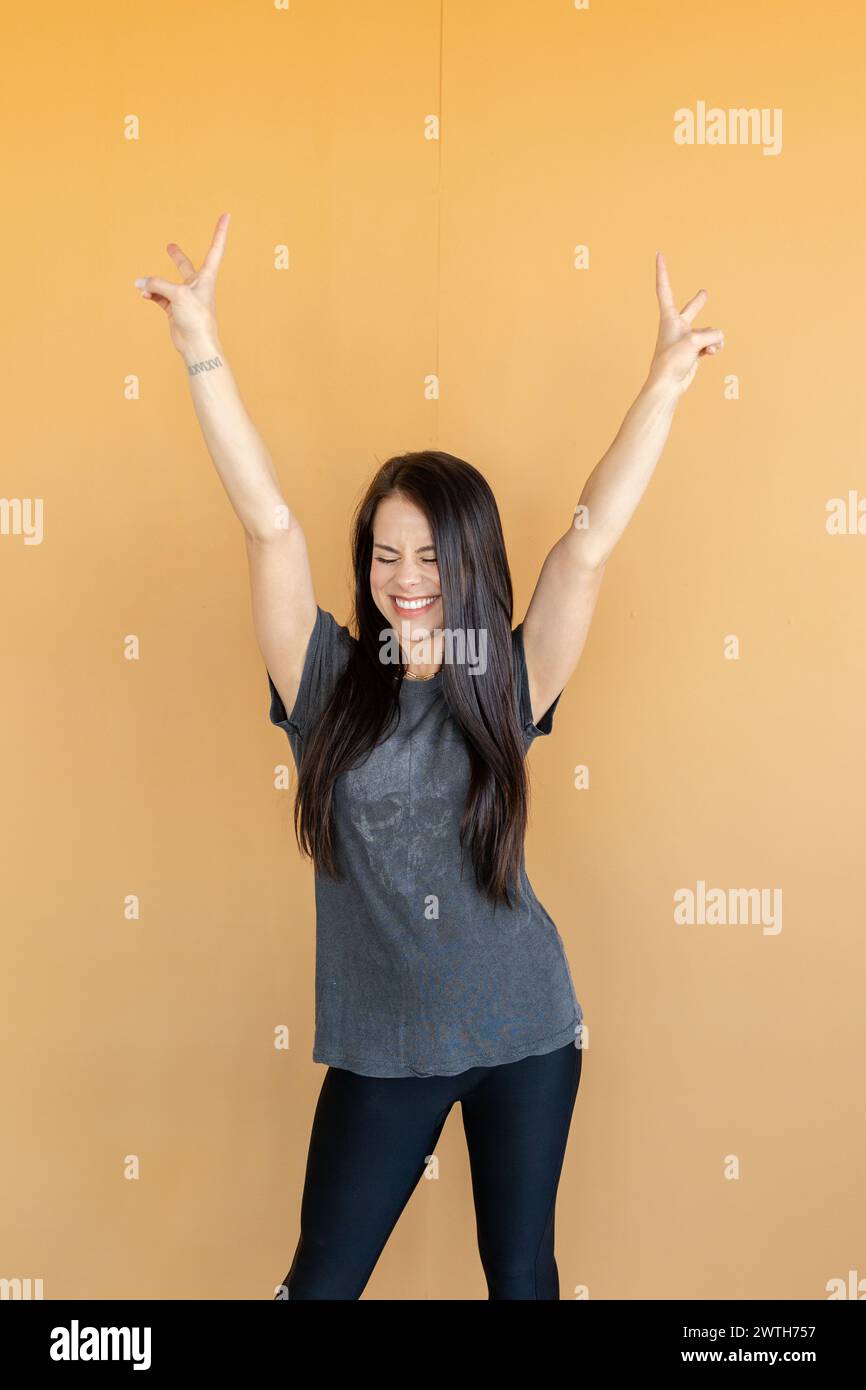 Donna gioiosa che fa segni di pace Foto Stock