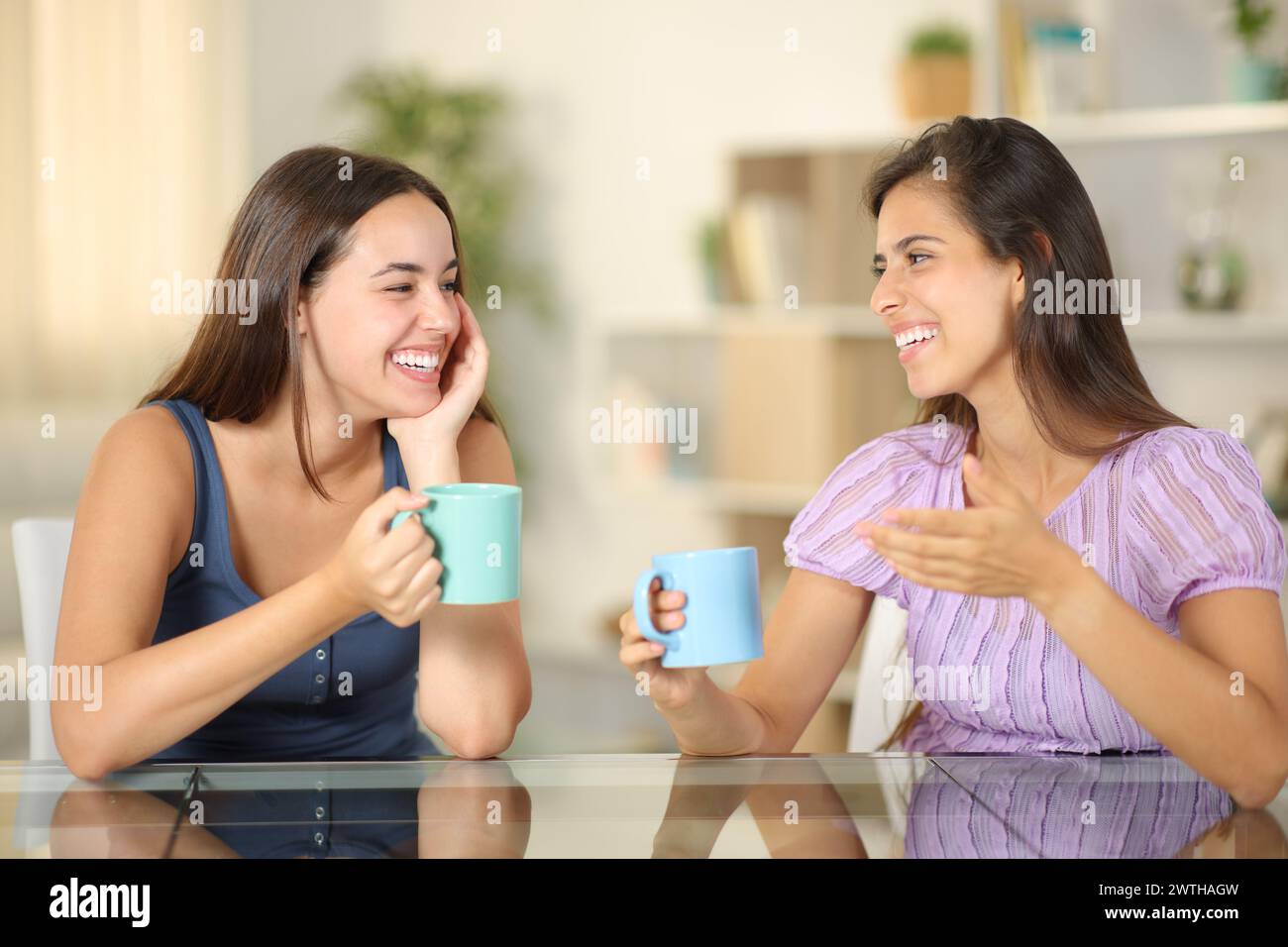 Due amici che parlano bevendo un caffè a casa Foto Stock