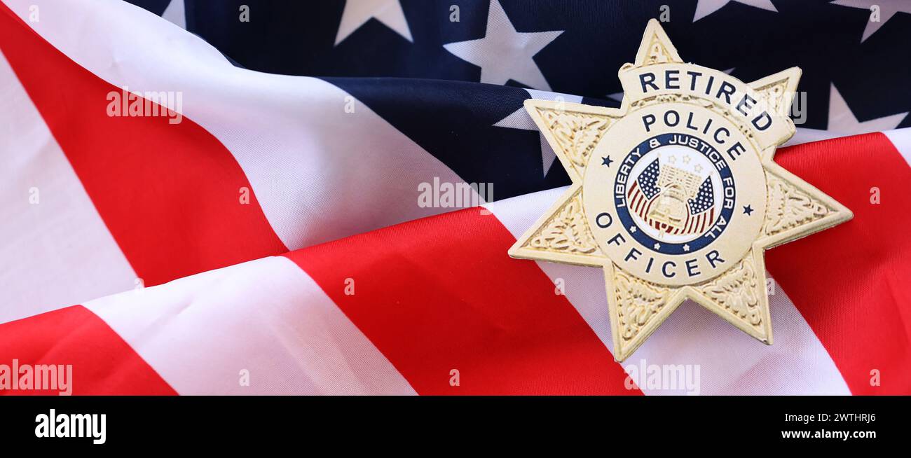 KIEV, UCRAINA - 9 MARZO 2024 distintivo dell'ufficiale di polizia in pensione statunitense sulla bandiera degli Stati Uniti d'America primo piano Foto Stock