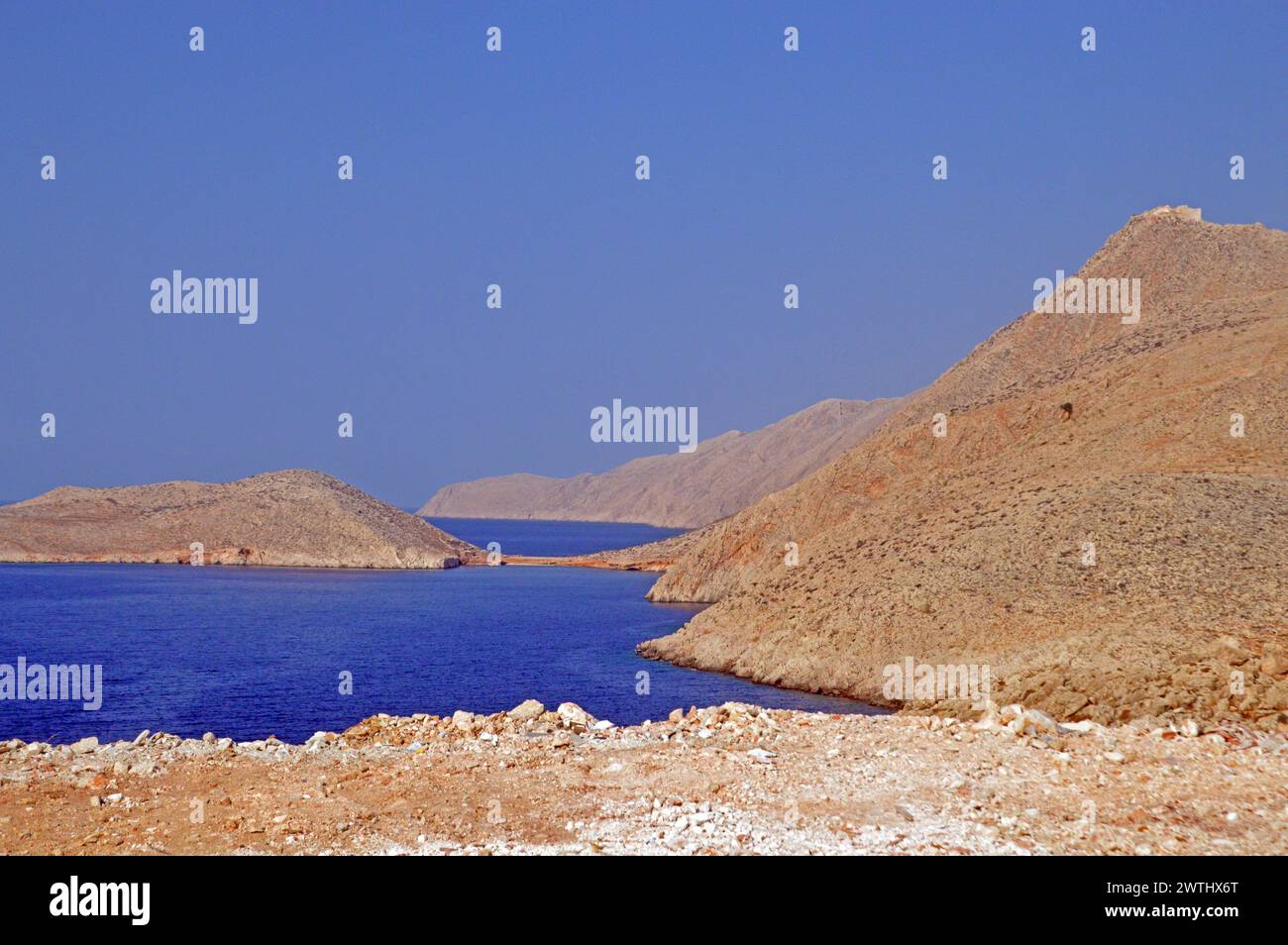 Grecia, isola di Chalki: Rovine di una fortezza bizantina su una collina arida che domina la costa, senza vegetazione. Foto Stock