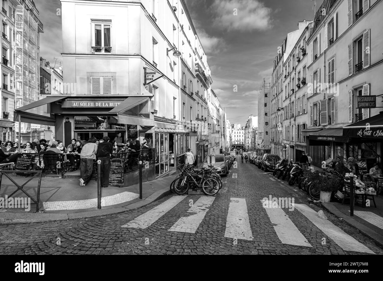 Parigi, Francia - 17 febbraio 2024: Veduta delle persone sedute all'aperto e gustate la cena e le bevande in un ristorante bistrot a Montmartre Parigi Francia Foto Stock
